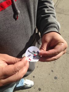 Young man putting on an "I Voted" sticker after having placed his vote.